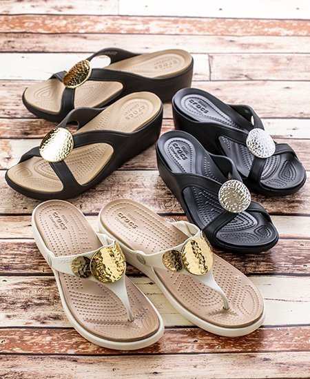 three pairs of Crocs sandals and wedges in black, beige, and white