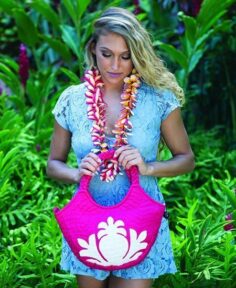 model holding a magenta quilted handbag with a pineapple motif