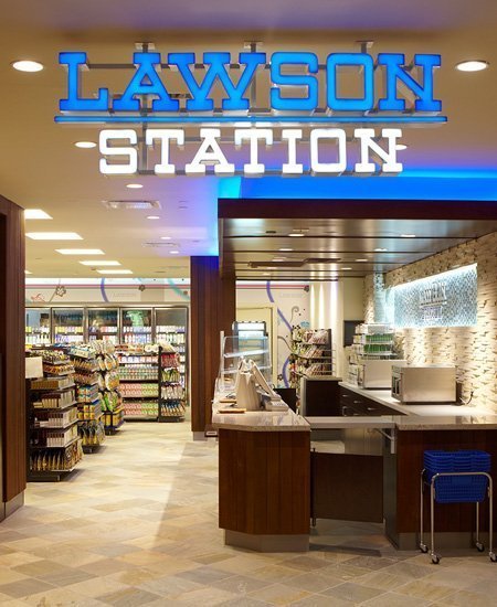 interior photo of the Lawson Station convenience store, showing the register area and logo