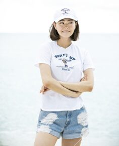 female model wearing a tanned Snoopy "Surf's Up" t-shirt and hat