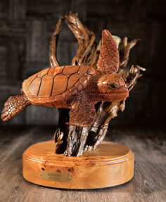 Hawaiian sea turtle (honu) carved out of Koa wood on a stand, at Martin & MacArthur at the Moana Surfrider