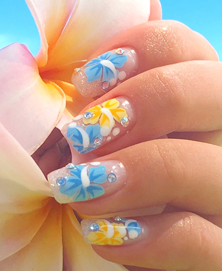 yellow and blue plumeria flower nail art by Naillabo on a female model's hand