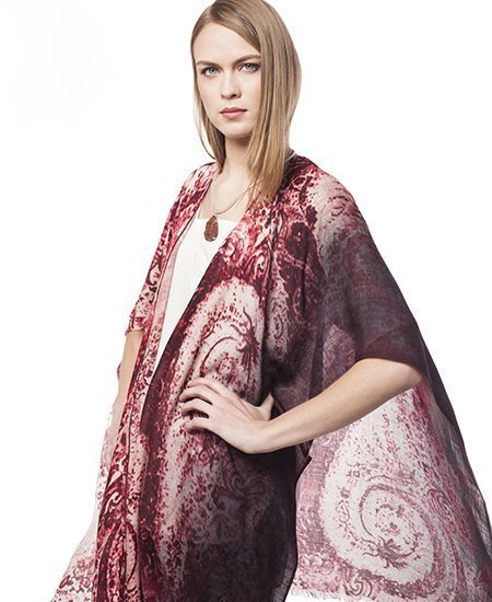 model posing with her hand on her hip, wearing a billowing maroon silk shawl