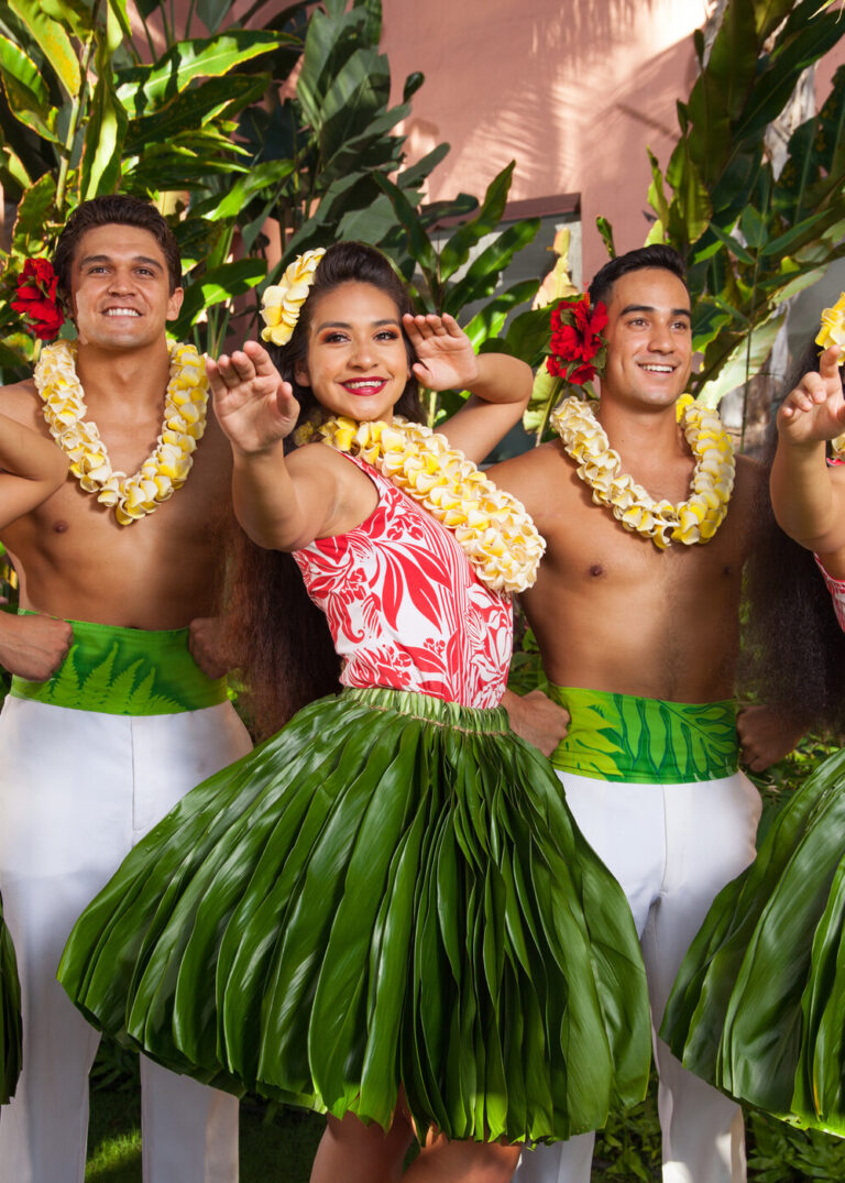 Aha Aina luau at the Royal Hawaiian Hotel, showing one female hula dancer and two male hula dancers