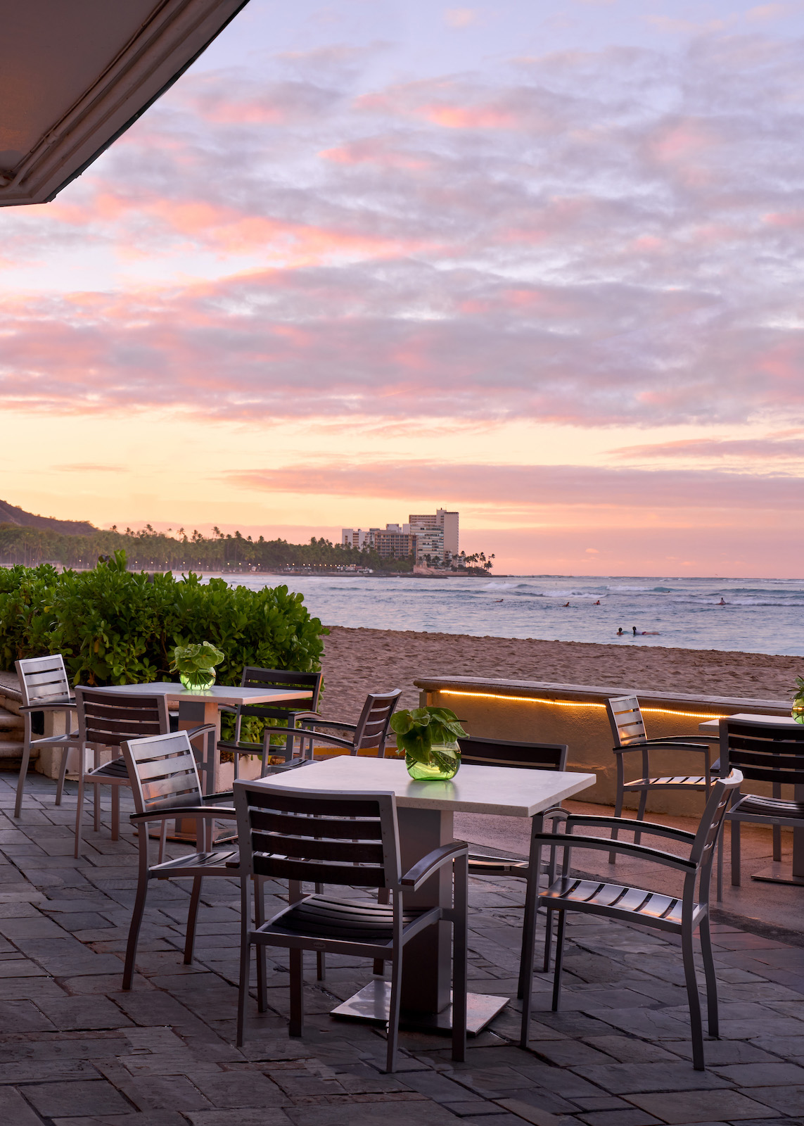 evening view of the Beach Bar at the Moana Surfrider with Waikiki Beach and Diamond Head in the backdrop