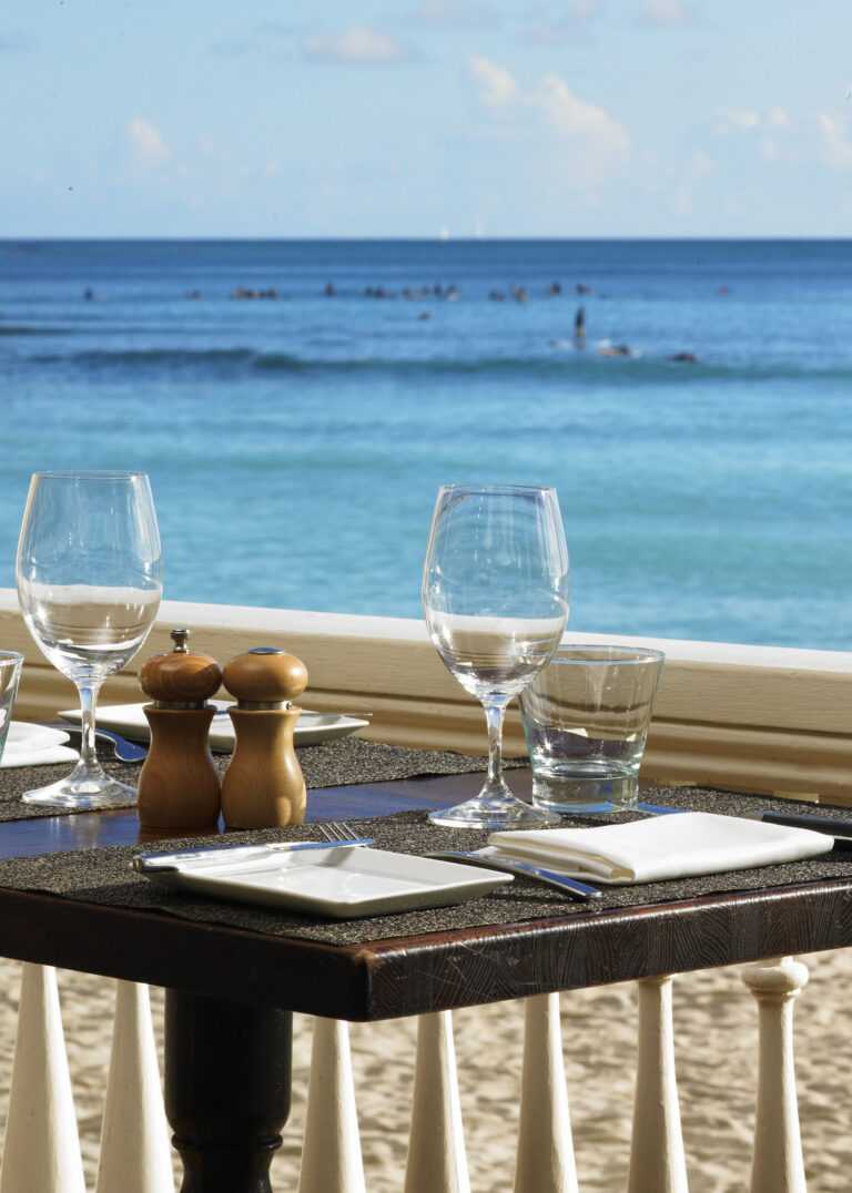 daytime view of a table setting in front of Waikiki Beach at the beachhouse at the moana