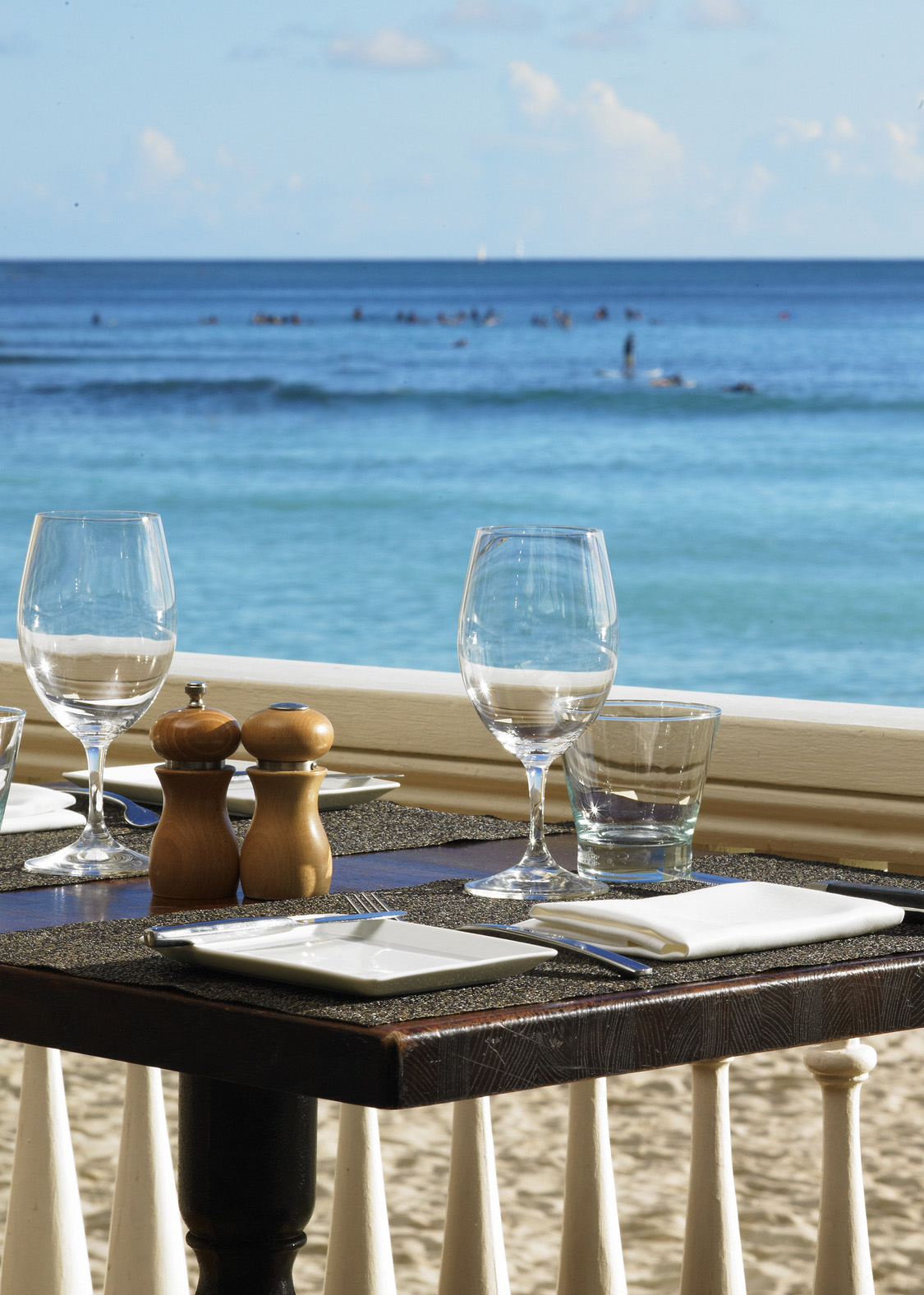 daytime view of a table setting in front of Waikiki Beach at the beachhouse at the moana