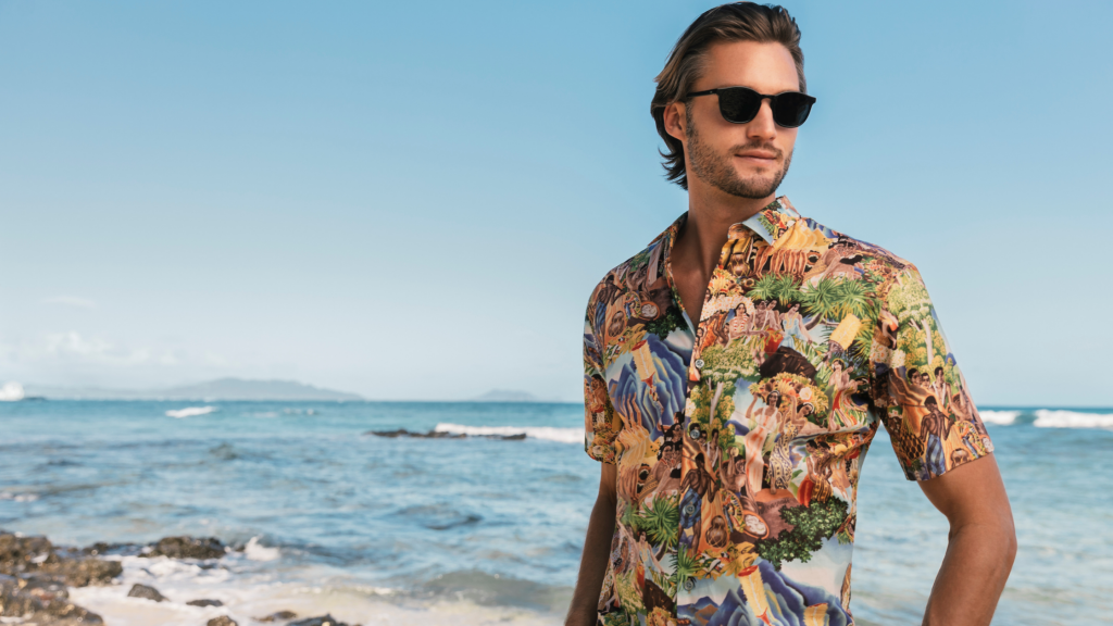 Tori Richard, a local Hawaiian clothing brand, photo of a caucasian male wearing a multicolor aloha shirt and sunglasses.